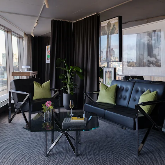 Clarion Hotel® Sign - Stratum Suite by Bernadotte and Kylberg. En stilfull svit med svart soffa, fåtölj och utsikt över staden.
