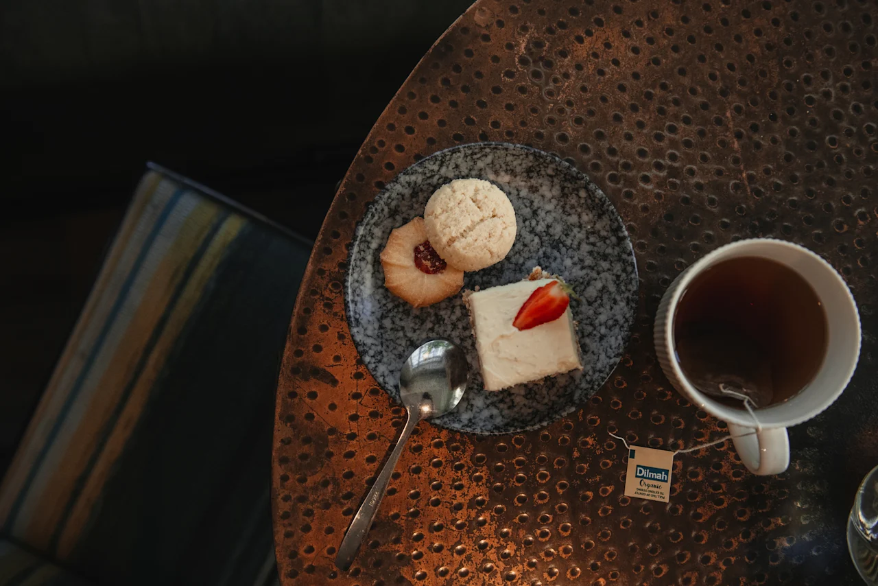 Enjoying a warm cup of organic tea with delicious cookies and a slice of cake at Home Hotel Uppsala.