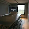 Ett modernt konferensrum på Stopover Hotel Falkenberg med en stor skärm som visar "MORE TO EXPLORE" och ett långt bord med stolar.