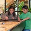 Barn som spelar shuffleboard på Quality Hotel The Reef, där ett barn sträcker sig efter pucken och ett annat tittar på.