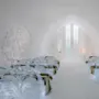 Elegante isbænke dekoreret med indviklede udskæringer står på række i et snækapel. Bløde pelser dækker sæderne. Delikate mønstre dekorerer væggene, suppleret af blød belysning.