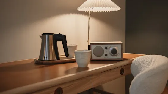 Et hyggeligt skrivebord med elkedel, kopper, radio og lampe på Home Hotel Wellington.