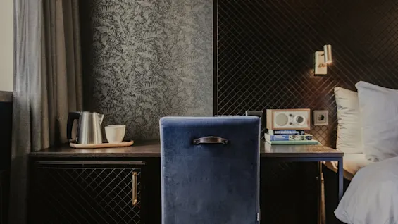 Ett bekvämt hotellrum med arbetsplats och mysig sängplats, perfekt för avkoppling eller arbete.