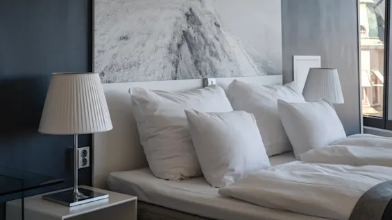 A comfortable hotel room at Clarion Hotel Sign with a neatly made bed, white linens, and bedside lamps, ready for a relaxing stay.