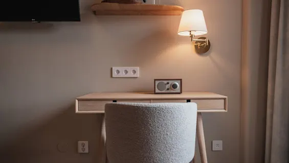 Home Hotel Wellington: Et hyggeligt skrivebordsområde på hotelværelset med lampe, radio og TV, klar til arbejde eller afslapning.