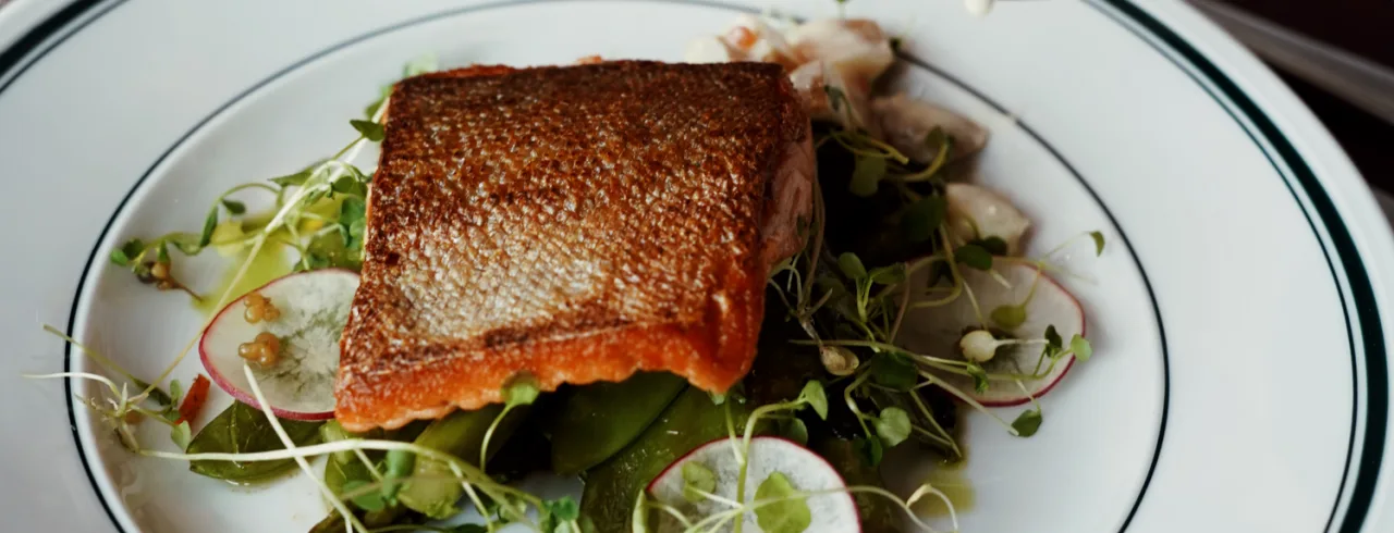 A fish dish served to a table at NÒR restaurant.