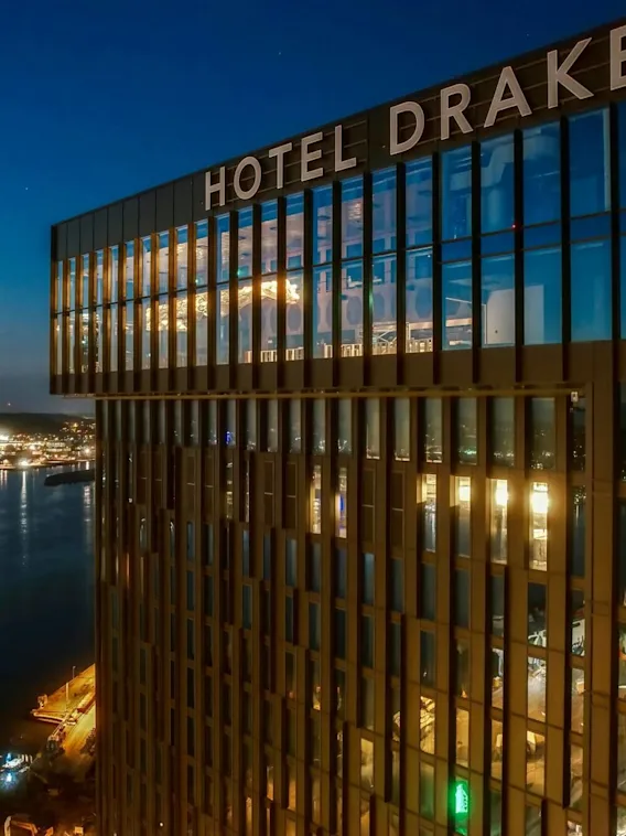 Fasad på Clarion Hotel Draken på natten, med havet i bakgrunden.