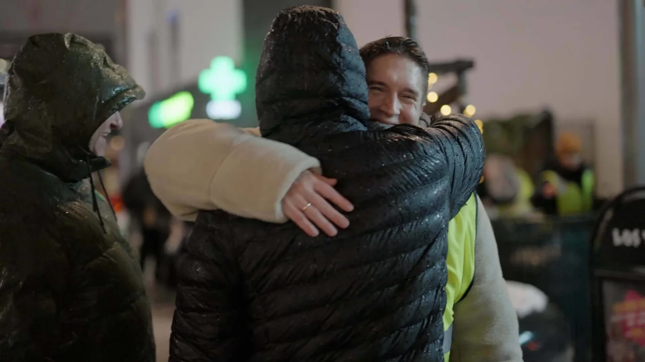 Two people hugging each other outside during winter.