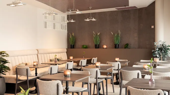 A cozy restaurant dining area with many tables set with candles, ready for guests.