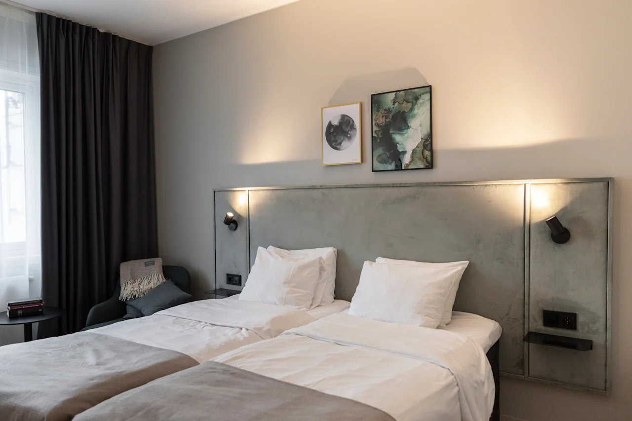 Astu mukavuuteen! Tässä kutsuvassa hotellihuoneessa on kaksi viihtyisää sänkyä, tyylikäs sängynpääty pehmeällä valaistuksella ja modernia taidetta.