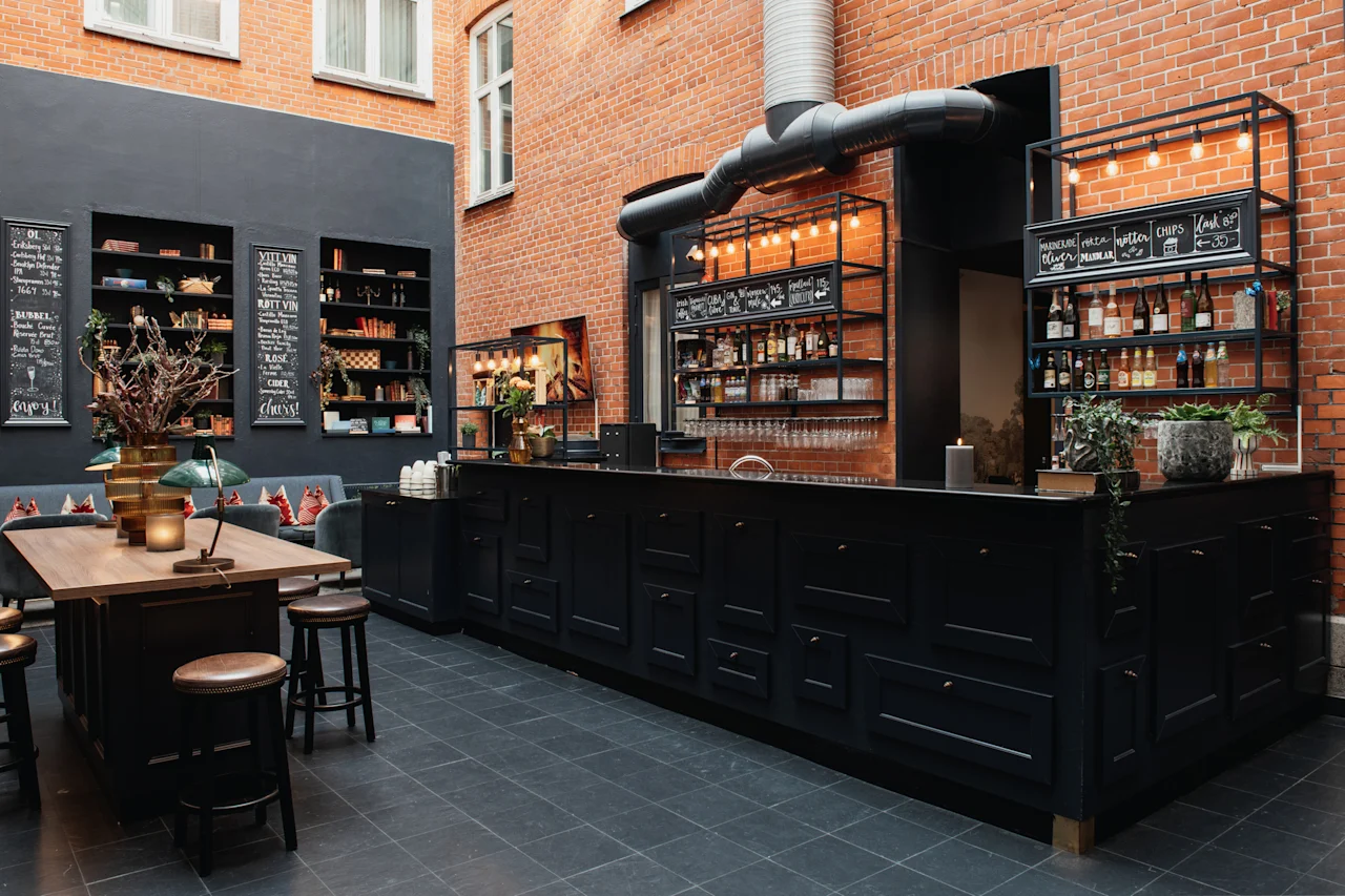 En bar og lounge. Tekst: OL BUBBEL enjoy! VITT VIN ROTT VIN ROSE CIDER cheers! snacks oliver marinerade notter chips.