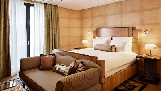 Et luksuriøst hotellrom med en stor seng og elegant sofa, rolig og godt opplyst, inviterer til avslapning.