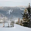 The iconic Torch man is visible on the mountain slope in wintertime in Lillehammer, Norway.