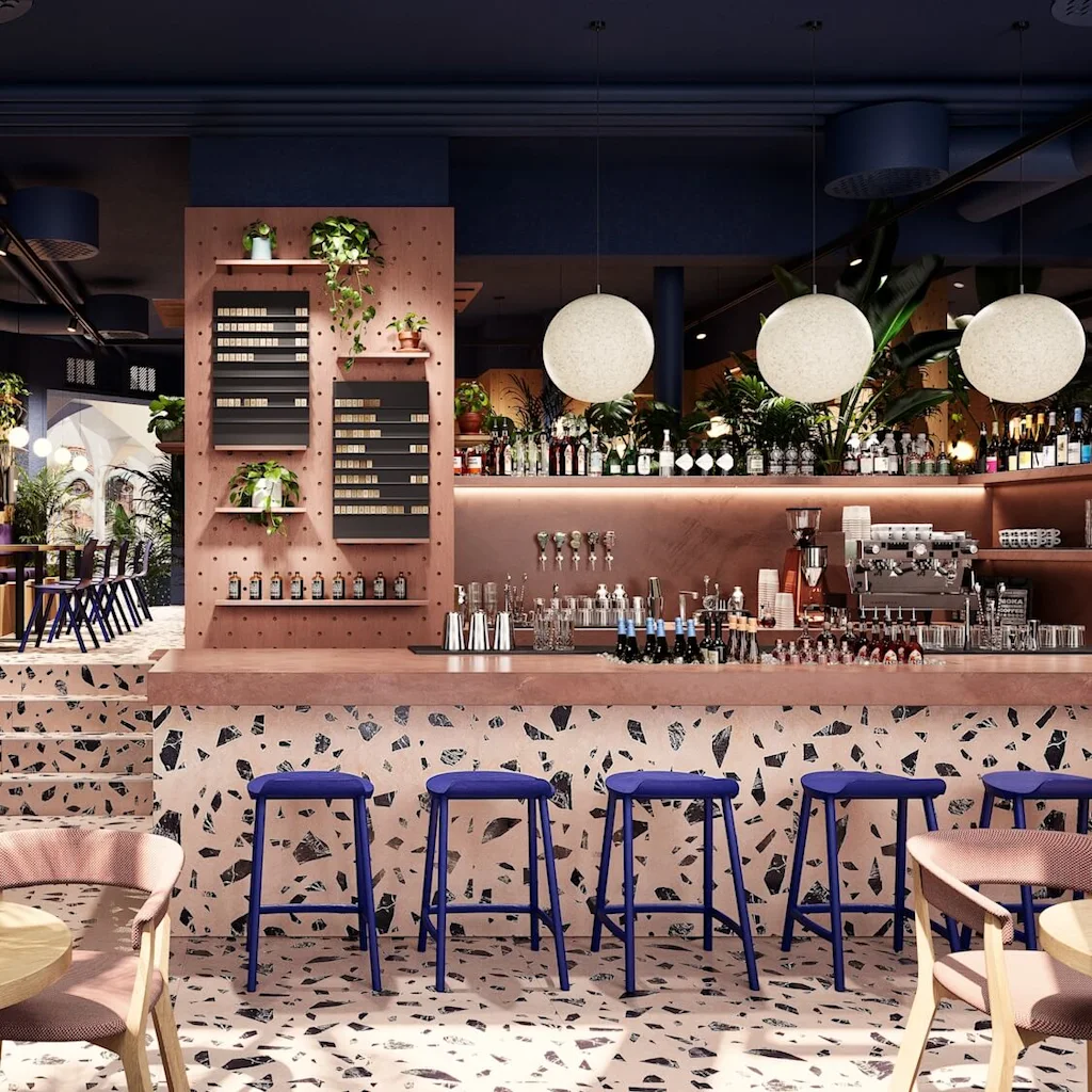 A bar area features a pink terrazzo counter with blue stools; shelves behind display bottles and plants. Round lights hang above. Nearby, tables and chairs are set in a lush, plant-decorated setting.