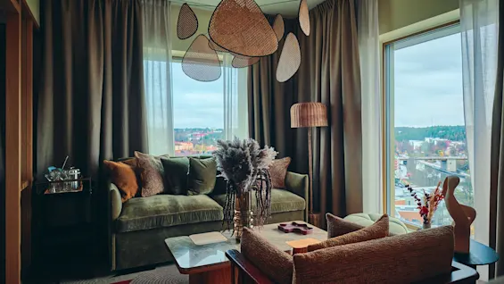 En stilig og koselig stue med sofa, stoler og salongbord, som tilbyr en naturskjønn utsikt over byen.