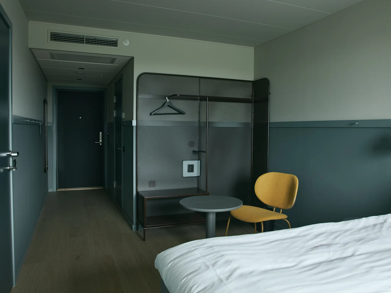 Ett välkomnande hotellrum på Stopover Hotel Falkenberg, designat för komfort med säng, sittplats och förvaringsutrymme.