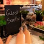 En livlig morgenmadsbuffet med Gulrot Smoothie-flasker på is, frisk vandmelon, druer og forskellige kornprodukter.
