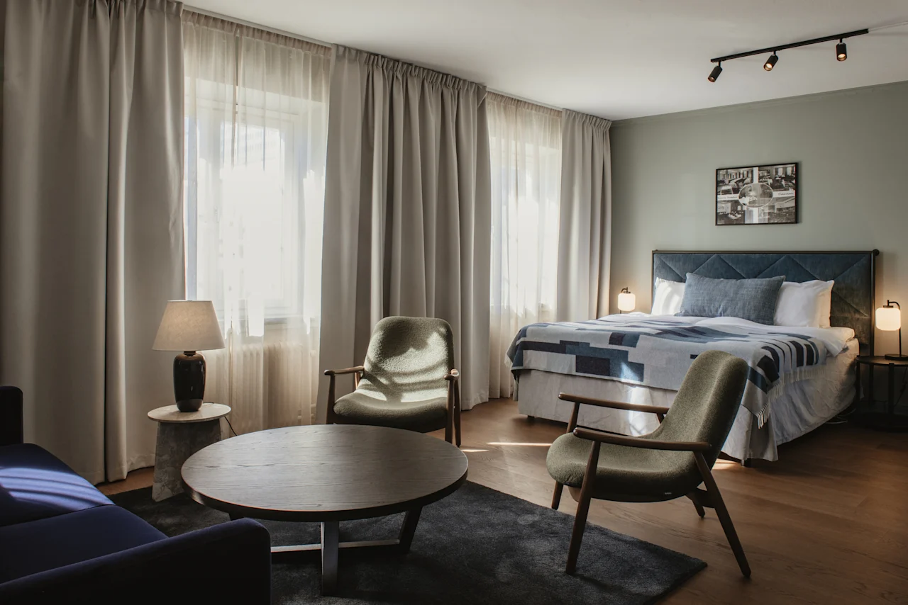 Ett inbjudande hotellrum med en bekväm säng och en separat loungeavdelning, perfekt för avkoppling.