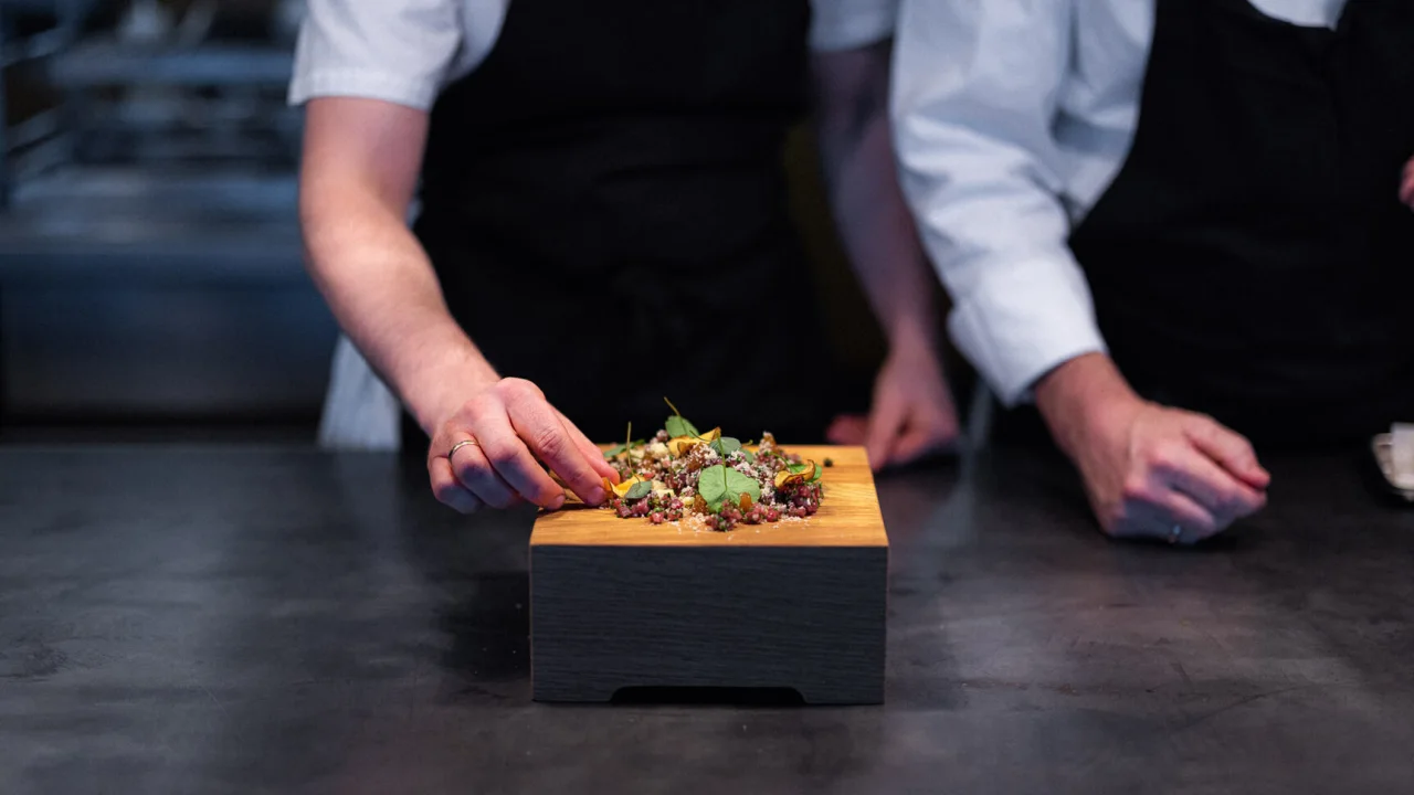  a cook presenting food on a plate