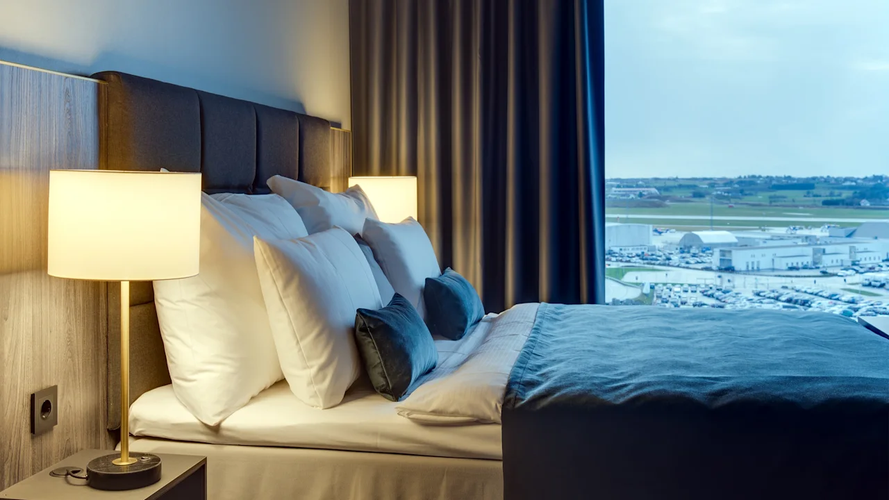 Et koselig hotellrom på Clarion Hotel Air med en komfortabel seng og utsikt over en flyplass fra vinduet.