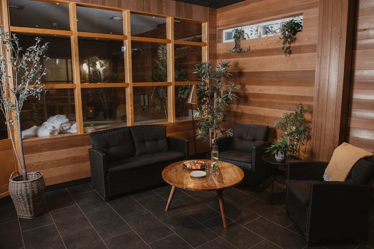 En avkopplande lounge med bekväma sittplatser, ett soffbord med förfriskningar och utsikt över ett lugnt spa.