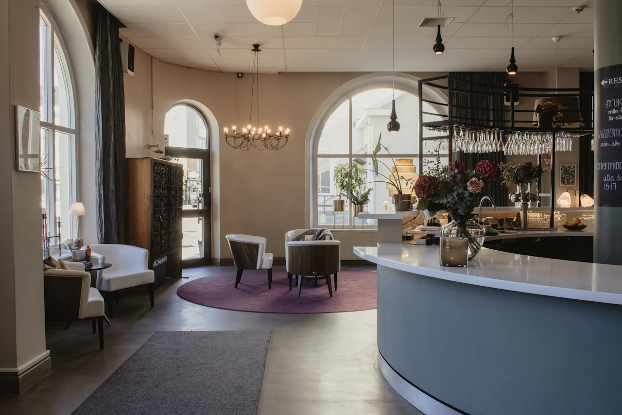 Home Hotel Post lobby med en välkomnande reception, bekväma sittplatser, välvda fönster. Skylt: RESTAURANT, middag 15-17.