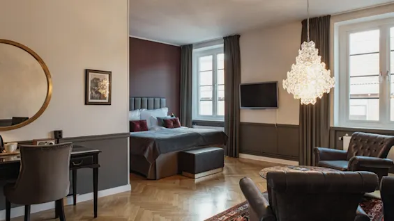 Tilava ja tyylikäs hotellisviitti, jossa on mukava makuuhuone, viihtyisä oleskelutila ja häikäisevä kattokruunu.