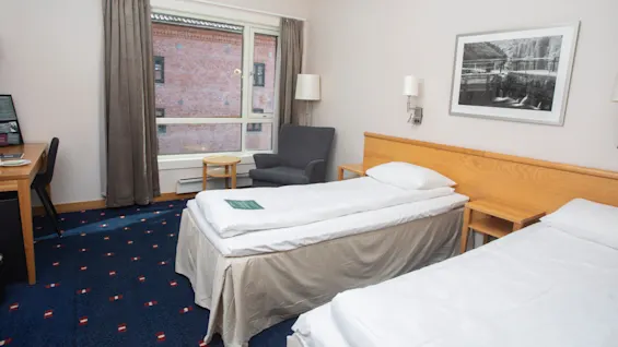 Standard twinroom at Home Hotel Bryggeparken, made bed and window.