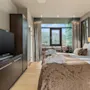 Et komfortabelt hotellrom på Quality Hotel Ulstein med to senger, en TV og en balkong som tilbyr en naturskjønn utsikt over byen.