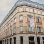 En fleretagers bygning med buet tag og murstensfacade. Et flag viser HOME HOTEL, og et vinduesskilt lyder TEMPERANCE HOME HOTEL.