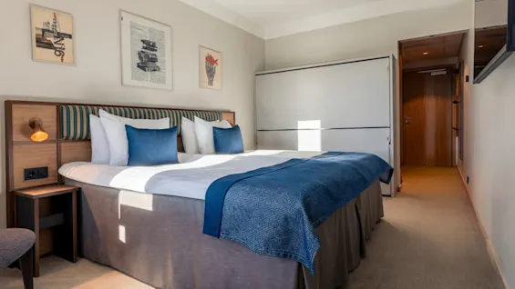 Quality Hotel The Book: A comfortable hotel room with a large bed, blue accents, and artistic decor.