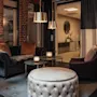 Et varmt og indbydende loungeområde med komfortable siddepladser, blød belysning og et skilt, der angiver WC tr ned.