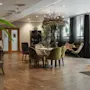 A cozy lounge area at Home Hotel Uppsala with various seating, plants, and doors labeled GYM and RELAX.