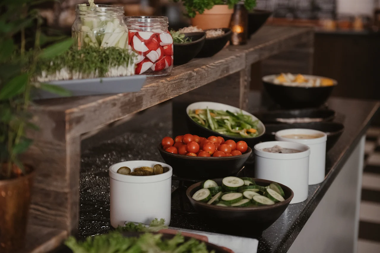 A vibrant buffet spread featuring an array of fresh vegetables and healthy ingredients in bowls and jars, ready for serving.