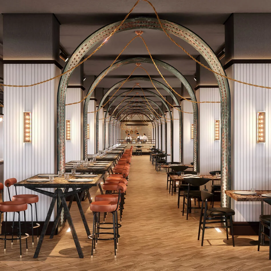 Restaurant interior features long tables with brown chairs. The ceiling has hanging lights and arches. Walls are white with decorative panels, and wooden flooring enhances a warm atmosphere.