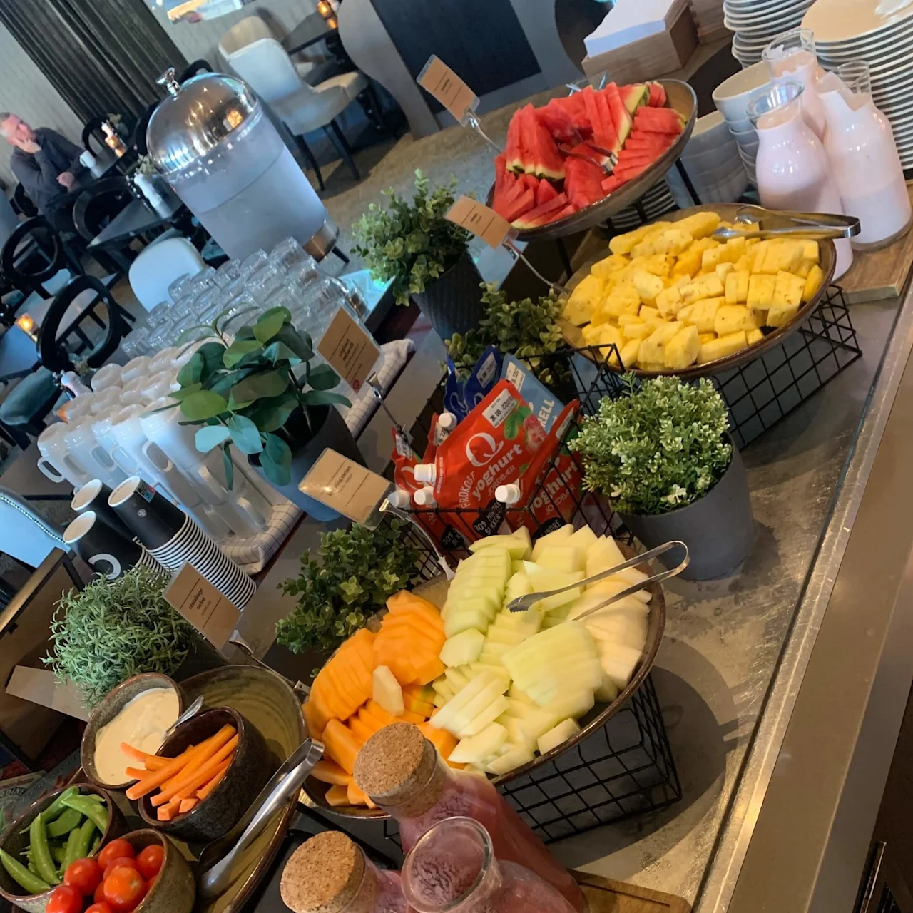 A variety of fresh fruits and vegetables are displayed on a buffet table as part of a catering setup.