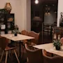 An inviting restaurant interior with warm lighting, wooden tables, leather chairs, and a chalkboard sign: THE TASTE IS ALWAYS COMFORTING.