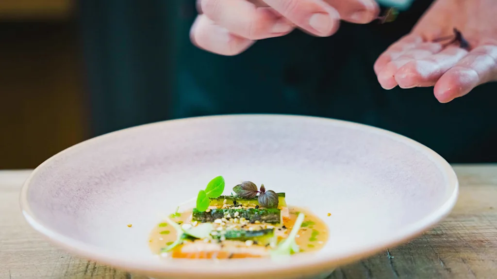 Frida Ronge plating a fish dish at restaurant TAK in Stockholm.