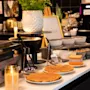En herlig frokostbuffé med nystekte vafler, diverse pålegg og et vaffeljern, som skaper en koselig og innbydende atmosfære.