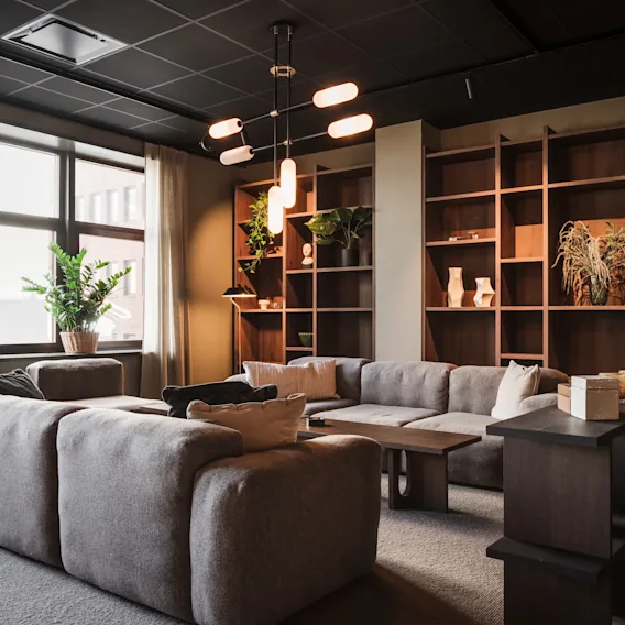En elegant och mysig hotellobby eller gemensam yta med gott om sittplatser, ett stort fönster och utvald inredning på hyllor.