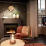 A warm and inviting hotel lounge with a lit fireplace and comfortable seating. Home Hotel Grand Bodø.