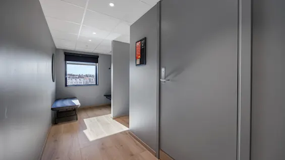 En lys, moderne korridor på Comfort Hotel Porsgrunn med vindusutsikt over byen og en innbydende inngang.