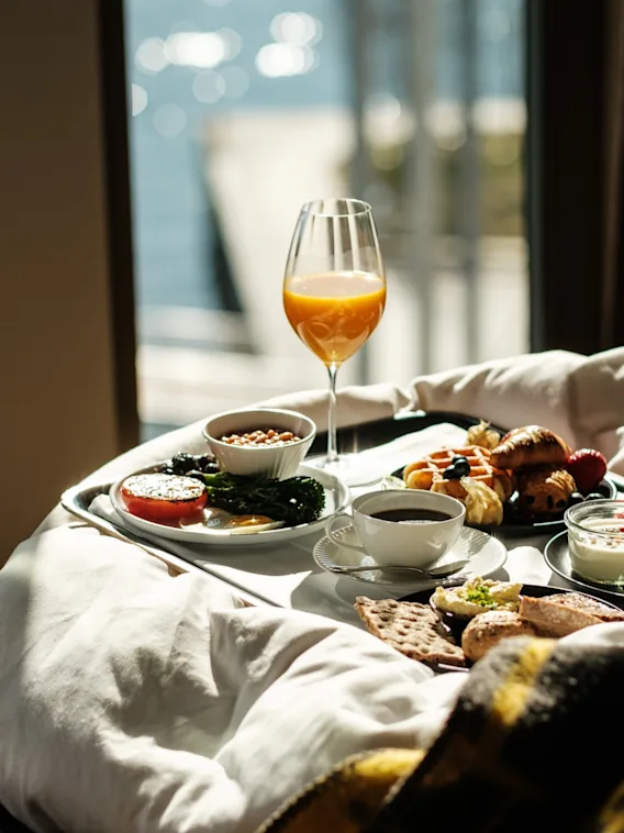 En deilig frokost på sengen med utsikt over vannet, nyt en avslappende morgen.