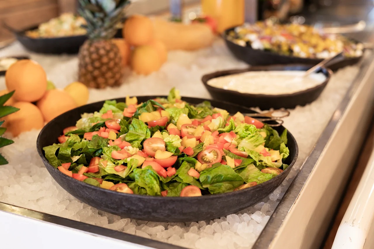 En levende buffetudstilling med en frisk salat med blandede grøntsager og farverige grøntsager, holdt kølig på is.