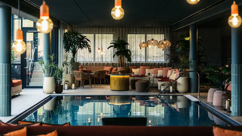 Indoor pool area at Lily Country Club with comfortable seating, lush plants, and warm, inviting lighting.