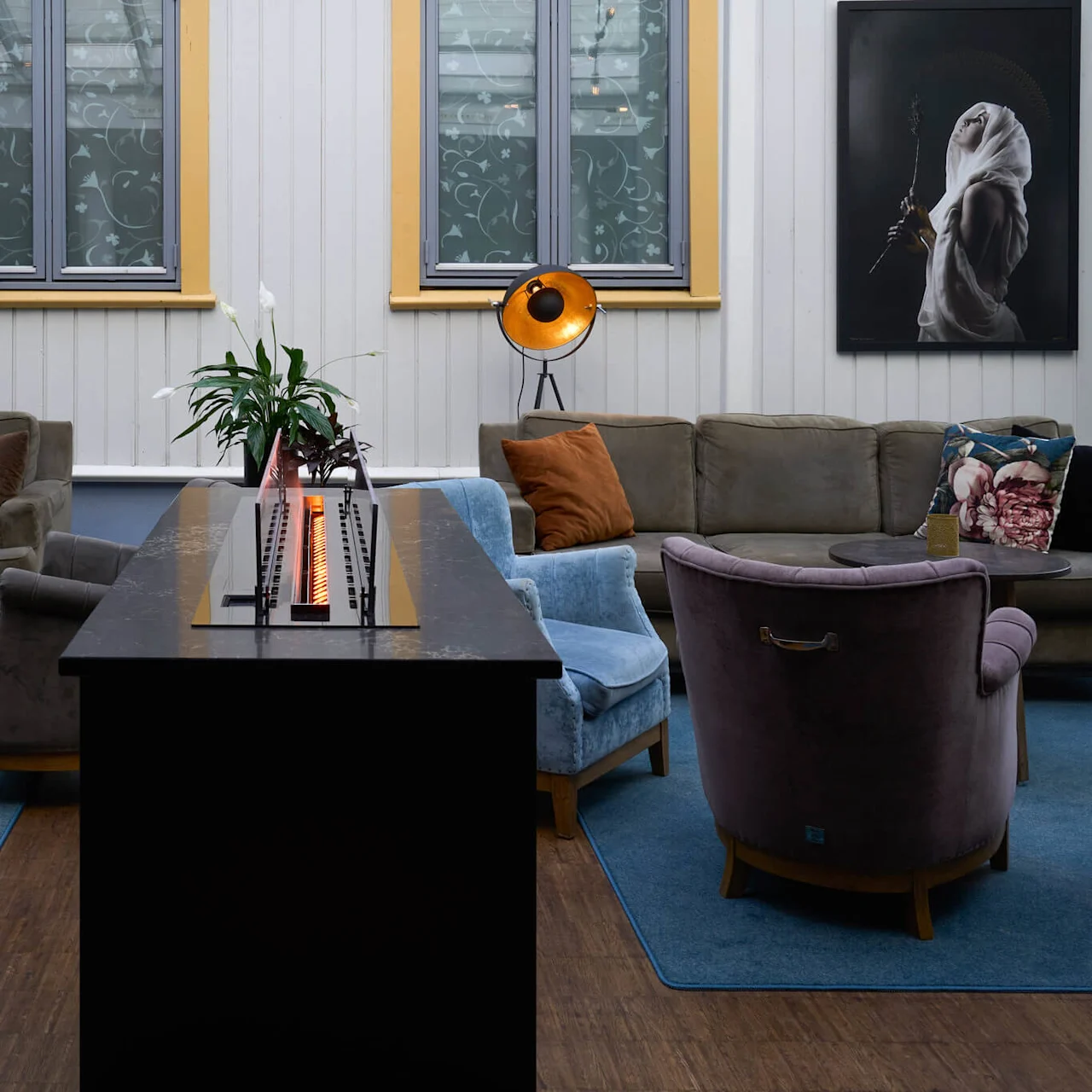 Et moderne dagligstue med komfortable siddepladser, stilfuld indretning, atmosfærisk belysning og et elegant pejs som centrum.