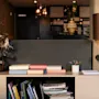 En indbydende hotellobby eller lounge med en dekorativ udstilling af bøger, et blomsterarrangement og en stilfuld lampe.