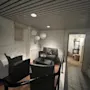 En rolig velværelounge på Home Hotel Bilan med komfortable kurvmøbler, hvite flislagte vegger og myk stemningsbelysning.