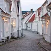 Idyllisk brosteinsgate med Gamlebyen Stavanger white wooden houses under en klar himmel.
