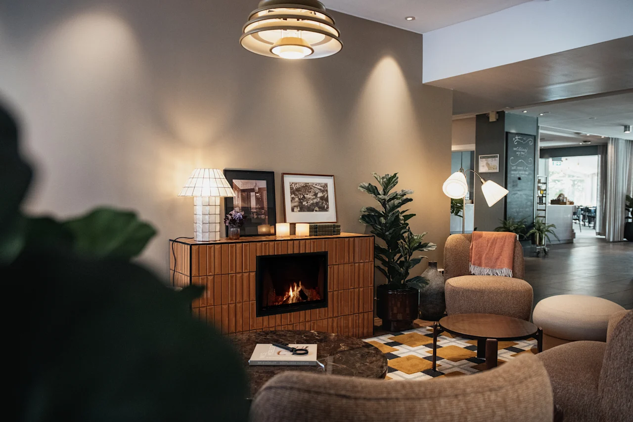 En inbjudande hotellobby med en varm öppen spis, mjuka sittplatser och stämningsfull belysning för en avkopplande upplevelse.
